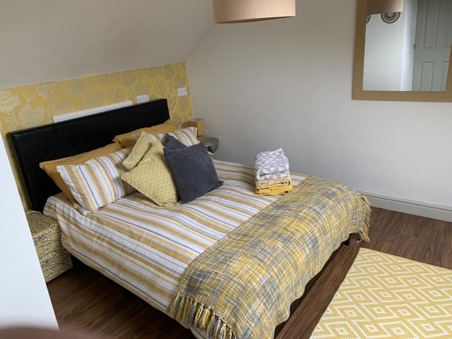 a bed with pillows on it in a bedroom at First floor Pad Carterton near Burford in Shilton