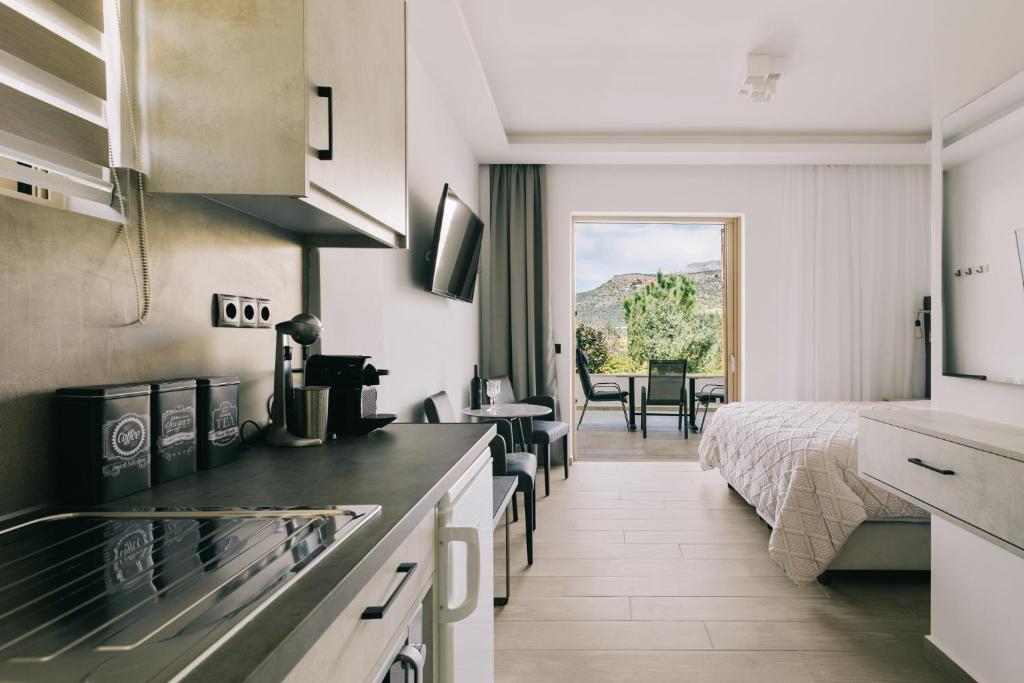 a kitchen with a bed and a room with a bed at Lighthouse Apartments in Stoupa