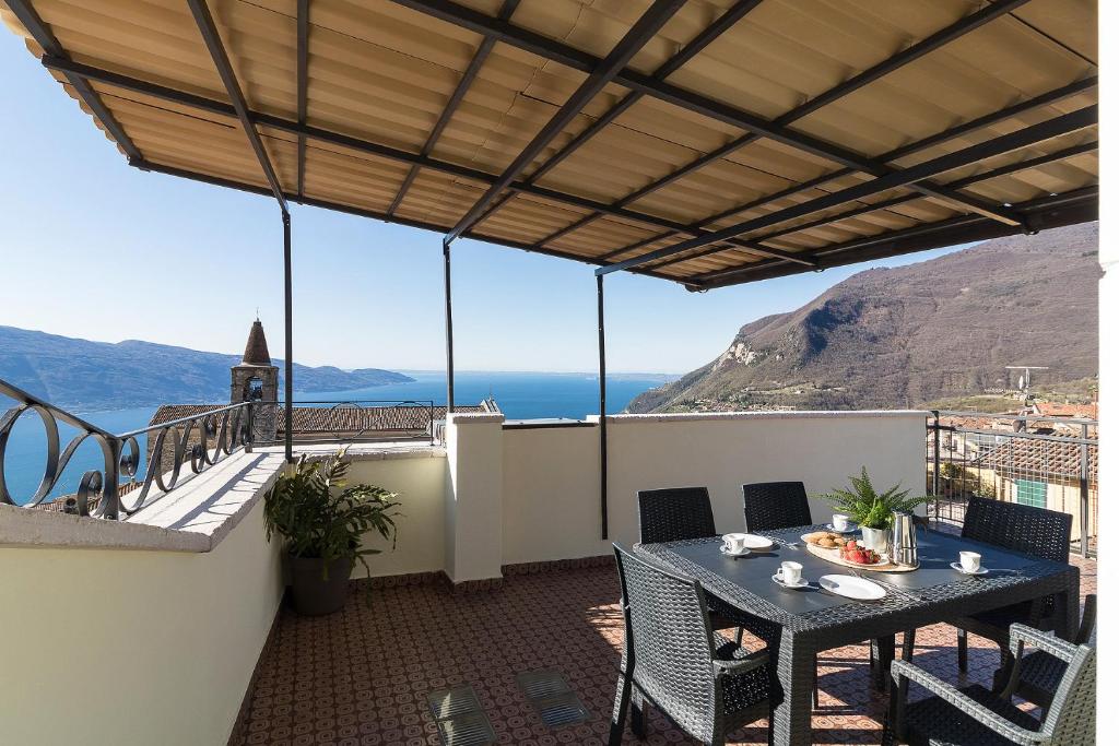 una mesa en un balcón con vistas al océano en Casa Marianna by Garda FeWo, en Tignale