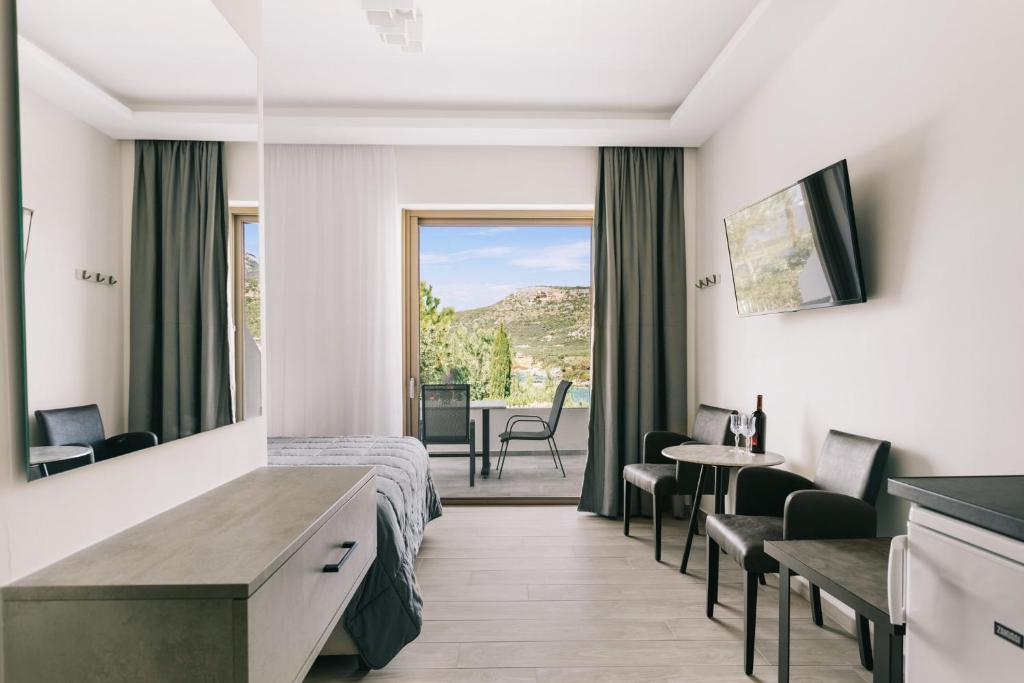 a hospital room with a bed and a table and chairs at Lighthouse Apartments in Stoupa