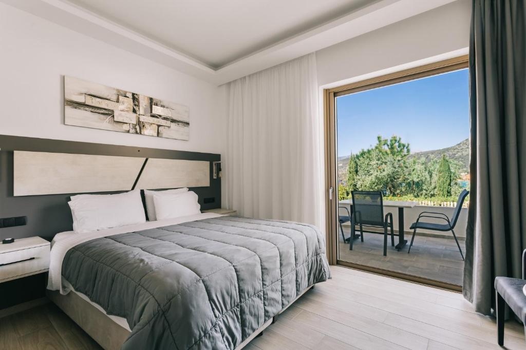 a bedroom with a bed and a sliding glass door at Lighthouse Apartments in Stoupa