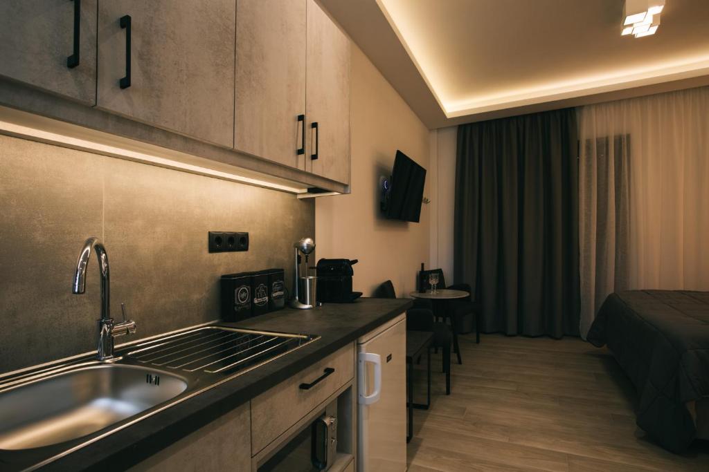 a kitchen with a sink and a bed in a room at Lighthouse Apartments in Stoupa