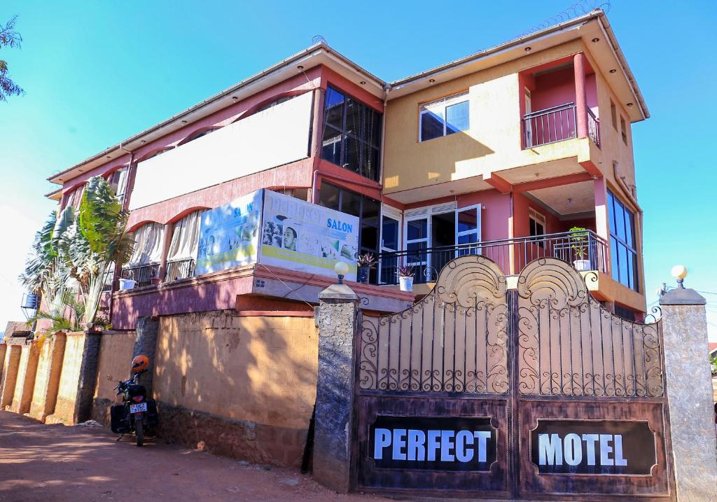 una casa con una puerta delante de ella en Perfect Motel en Kampala