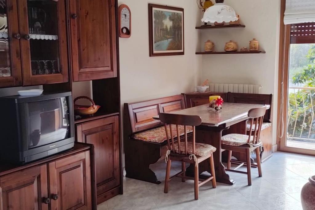 ein Esszimmer mit einem Tisch und einem TV in der Unterkunft Il nido dei cigni in Vogogna