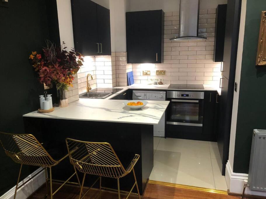 a kitchen with a counter and two chairs in it at Trendy 3 Bedroom Home Close To Margate Beaches Bars Resturants 2 Night Min Stay in Kent