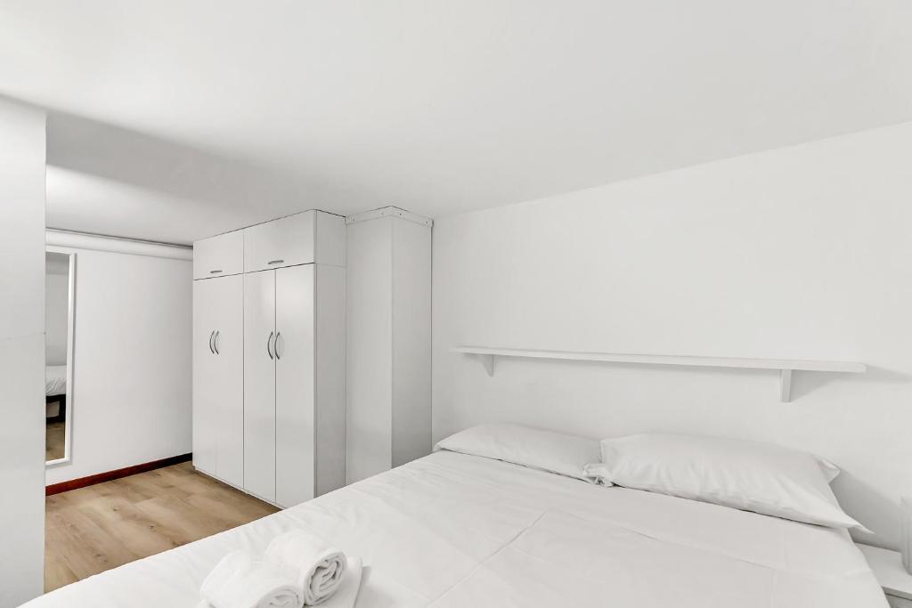 een witte slaapkamer met een groot bed en witte kasten bij Loft Daiquiri nel Centro di Milano, via Sottocorno, Porta Vittoria in Milaan