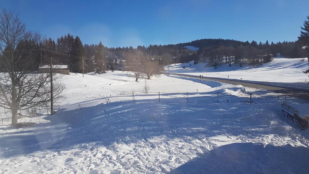 a snow covered slope with a ski lift at Appartement spacieux tout confort in Les Rousses