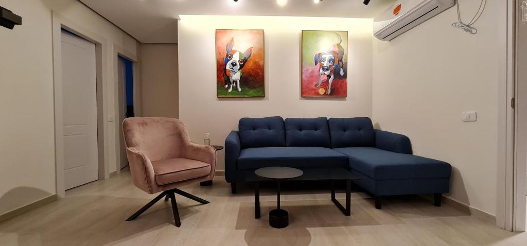 sala de estar con sofá azul y silla en Yuval holidey aprtment eilat en Eilat