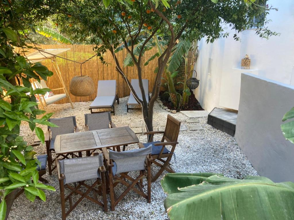 een patio met een tafel en stoelen en een boom bij Evis House in Chania