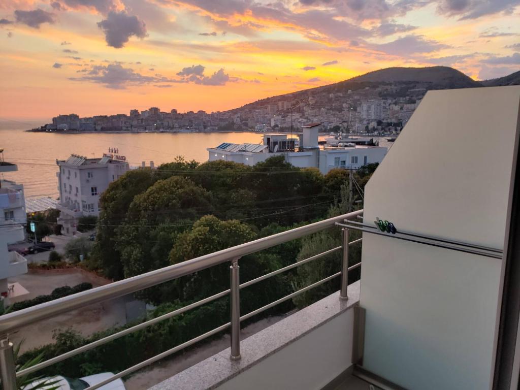 uma vista para o oceano a partir de uma varanda com um frigorífico em Eraldo's Rooms and Apartments em Sarandë
