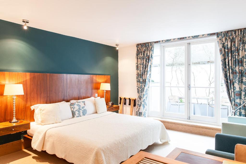 a bedroom with a large bed and a large window at The Rockwell in London
