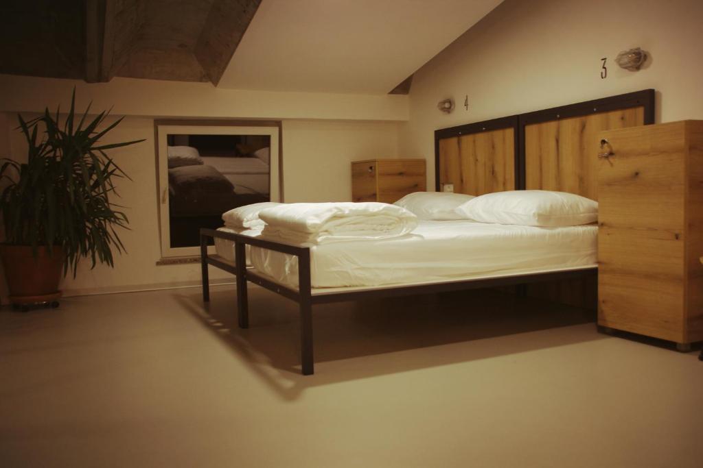 Schlafzimmer mit einem großen Bett mit einem Kopfteil aus Holz in der Unterkunft GARAGE HOSTEL in Nova Gorica