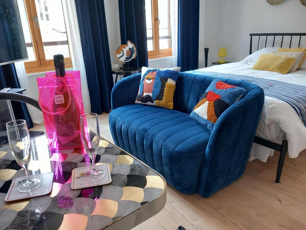 - un salon avec un canapé bleu et un lit dans l'établissement Résidence Beauvau – Numéro 3 - Centre de SARLAT, à Sarlat-la-Canéda