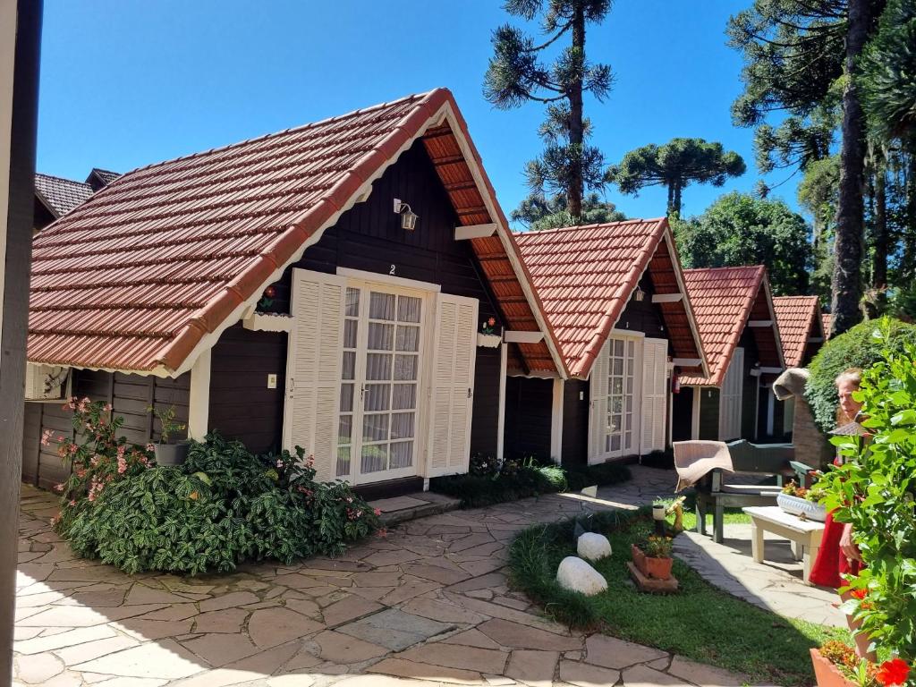 a row of cottages with red roof at Pousada Caliandra Da Serra in Canela