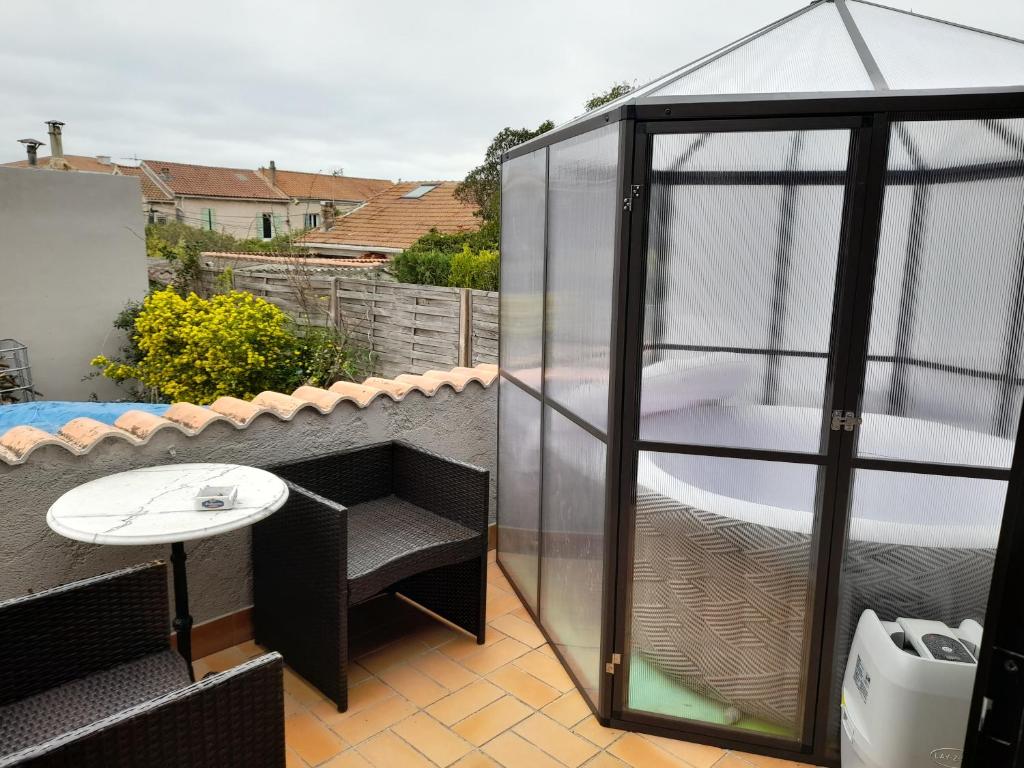 une maison en verre sur un toit avec une table dans l'établissement Cath's place, à Toulon