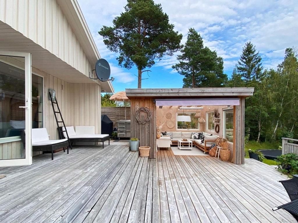 eine Holzterrasse mit einem Pavillon auf einem Haus in der Unterkunft Holiday home Åsenfjord 