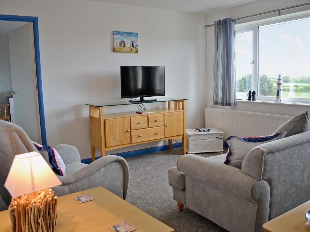 a living room with two chairs and a flat screen tv at Galleons Reach in Instow