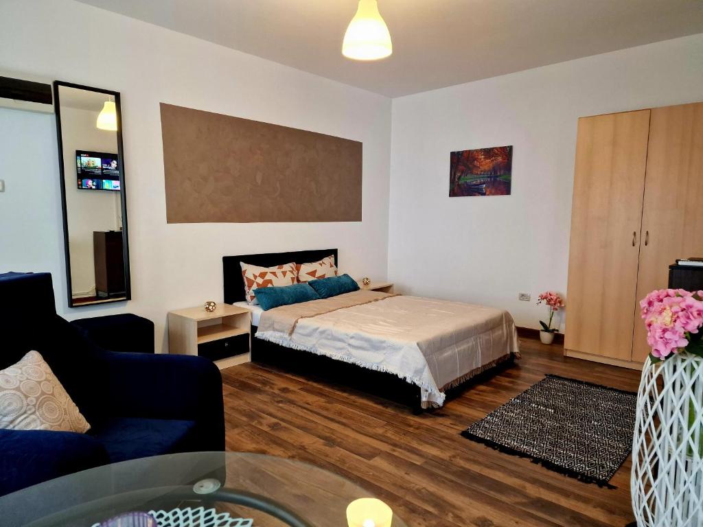 a bedroom with a bed and a living room with a couch at MBI Smart Central in Craiova
