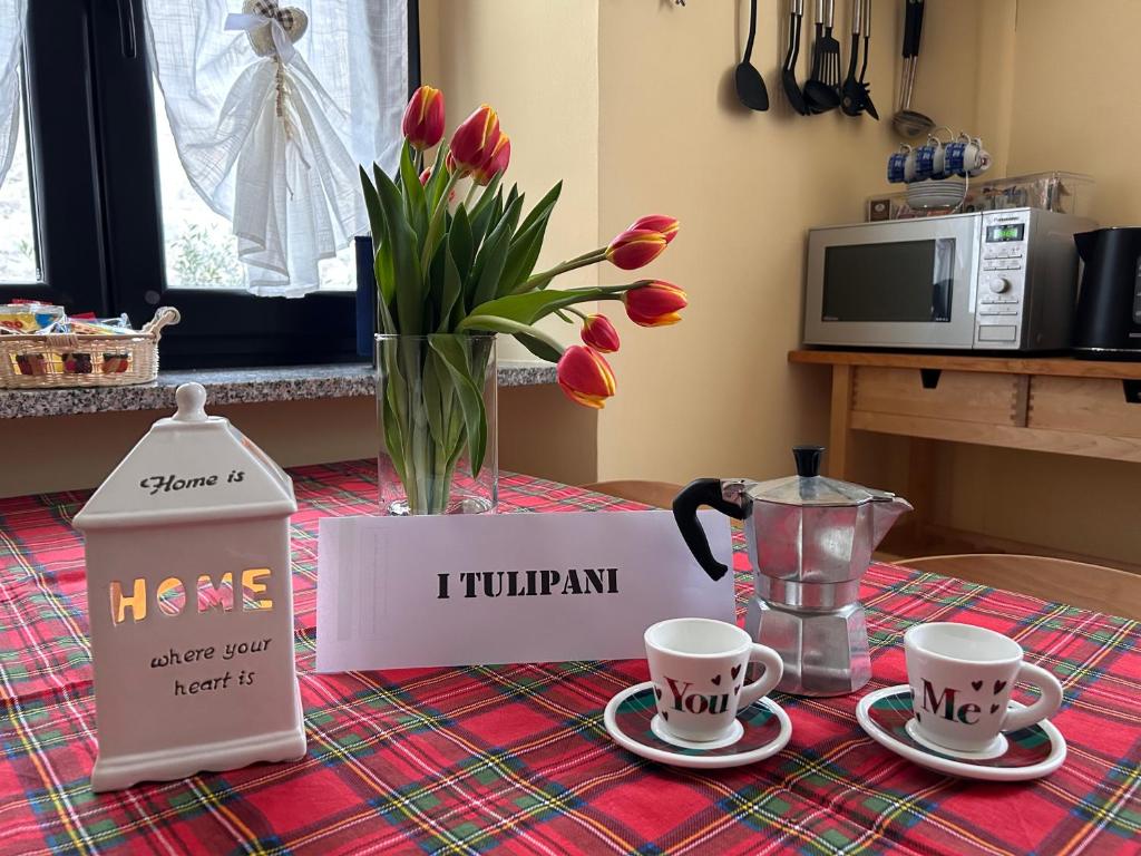 Uma mesa com duas chávenas e um cartaz que diz "tulandano" em i tulipani em Miagliano