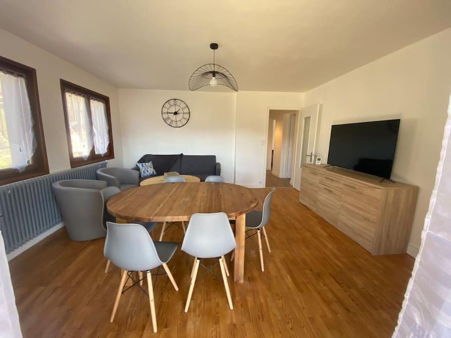 uma sala de estar com uma mesa de madeira e cadeiras em Logement entier dans maison - Passy - 6 personnes em Passy