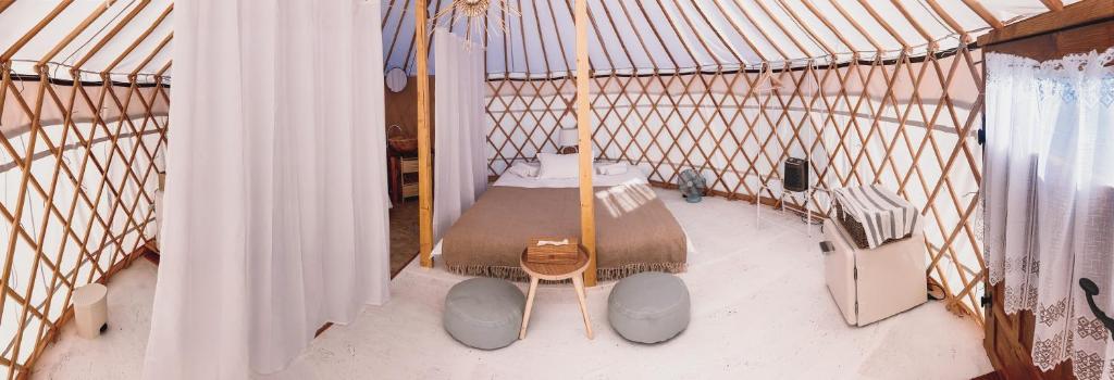 a hammock in a room with a bed at Glamping Iurte Mongole Spiritul Zimbrului in Vama Buzăului