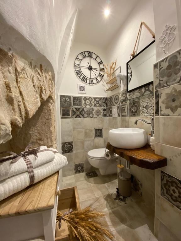 baño con lavabo y reloj en la pared en Domus Klara, en Turi