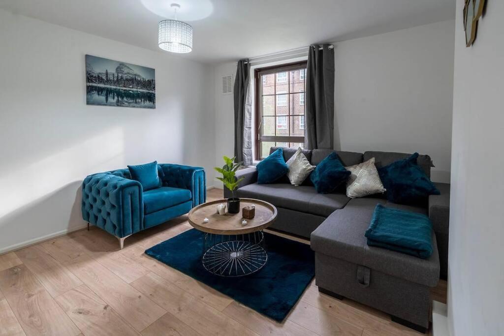 a living room with a couch and a blue chair at Fabulous apartment in the heart of Shoreditch in London