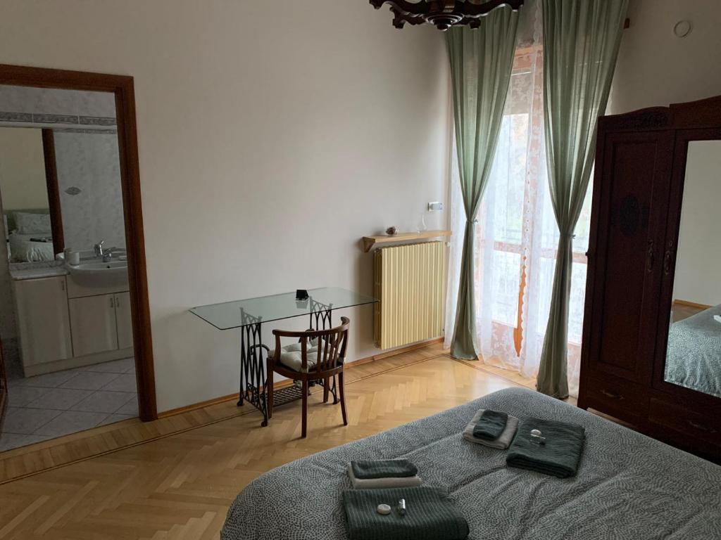 a bedroom with a bed and a table and a desk at La Pepita in Vallo Torinese
