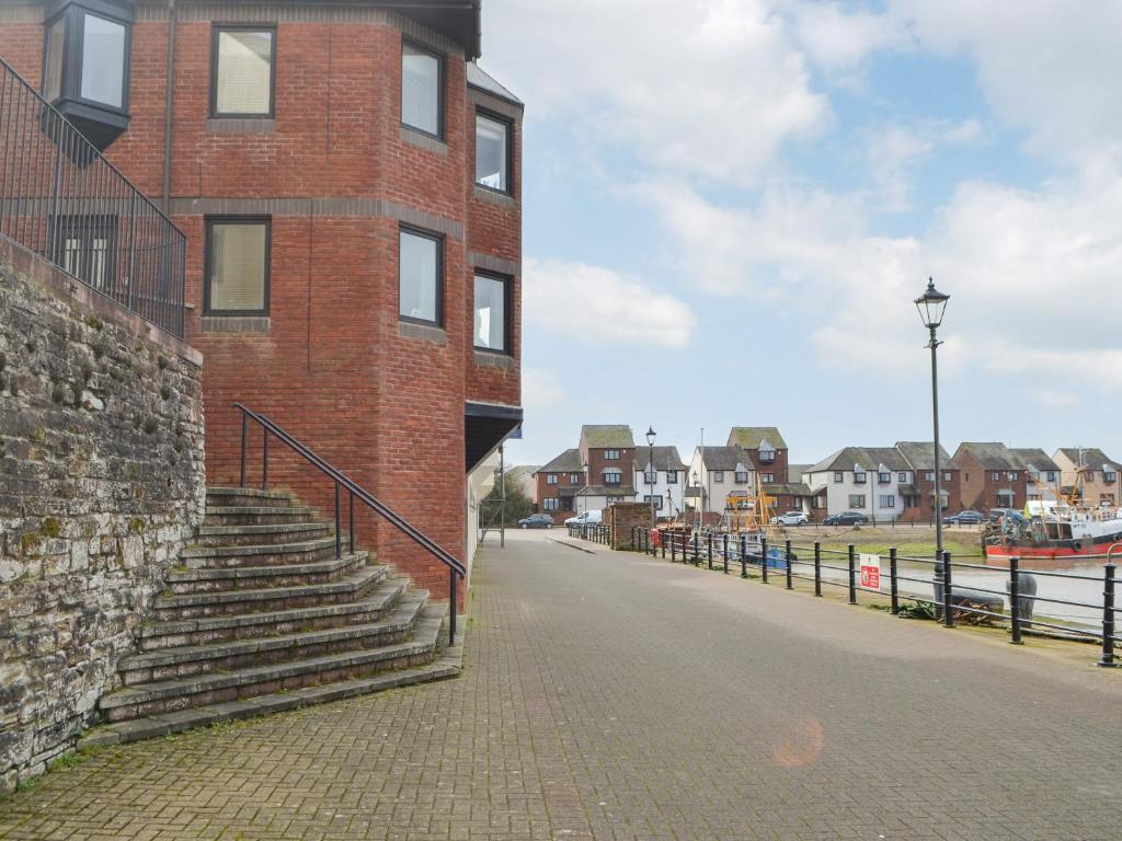 a brick building with stairs on the side of a street at Harbour Watch in Maryport