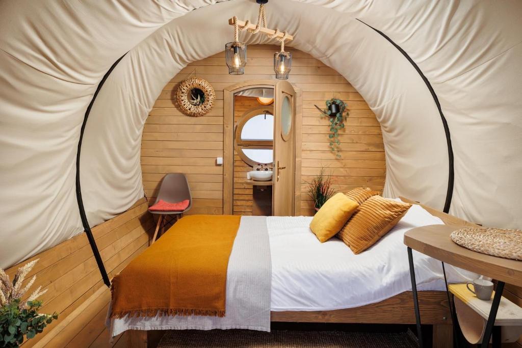 een slaapkamer in een tent met een bed erin bij Glamping Spiritul Zimbrului in Vama Buzăului