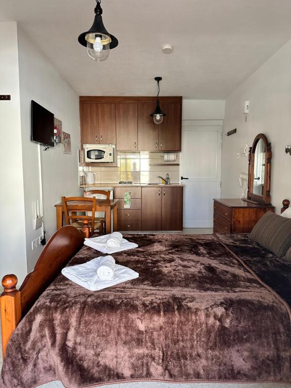 a bedroom with a large bed with two towels on it at Estia Vasilis Manoli in Ayia Napa