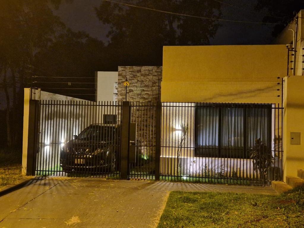 a gate in front of a building with a car behind it at Ferienhaus in Paraguay, Encarnacion, 200 Meter vom Parana. in Encarnación