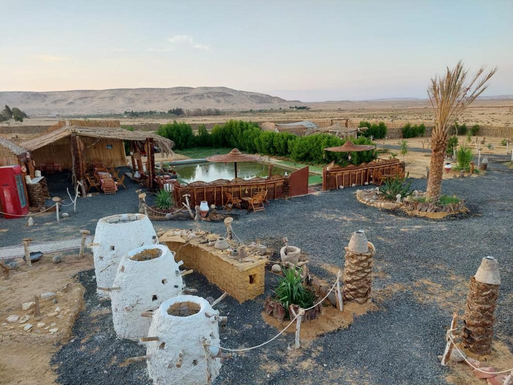 an outdoor area with tables and buildings in the desert at stars camp oasis in Bawiti