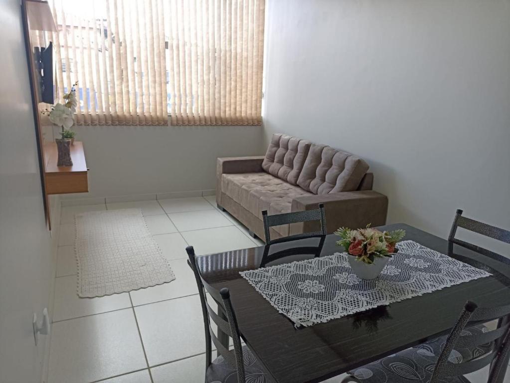 a living room with a table and a couch at 101-APT-Espaço,conforto.È disso que você precisa! in Anápolis