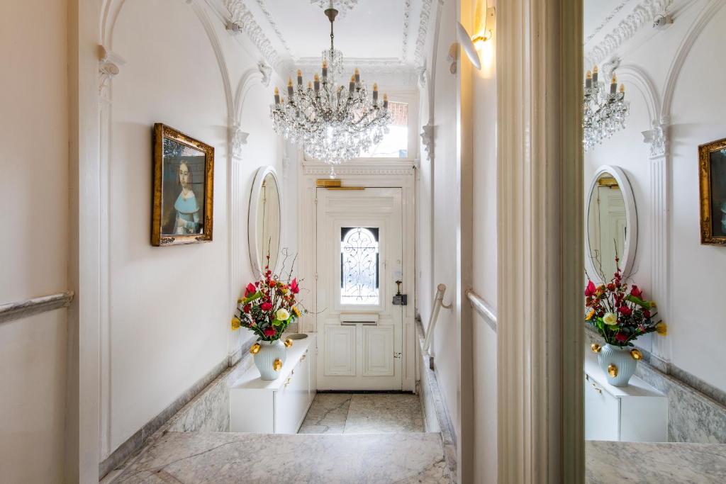 a hallway with a white door with two vases of flowers at Amstel Corner Hotel in Amsterdam