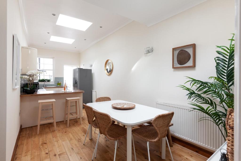 uma cozinha e sala de jantar com mesa e cadeiras em Kensington Nest Serviced House em Londres
