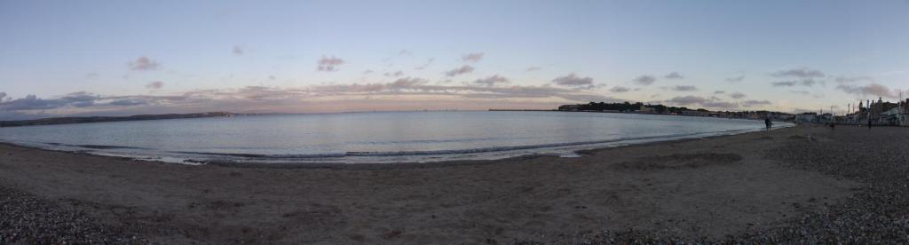 a beach with a large body of water at The Edenhurst Guesthouse in Weymouth