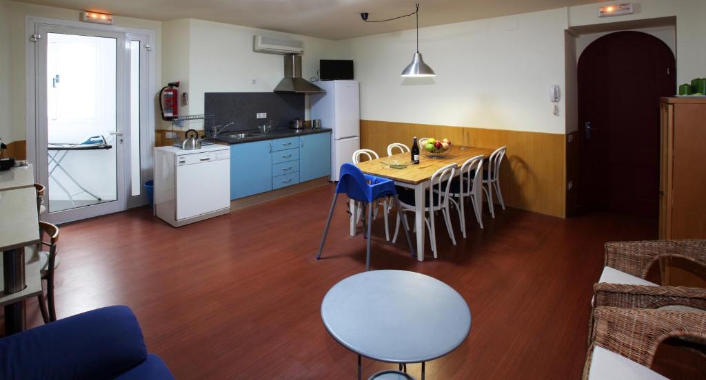 a kitchen with a table and a kitchen with blue cabinets at Apartamento Granollers in Granollers