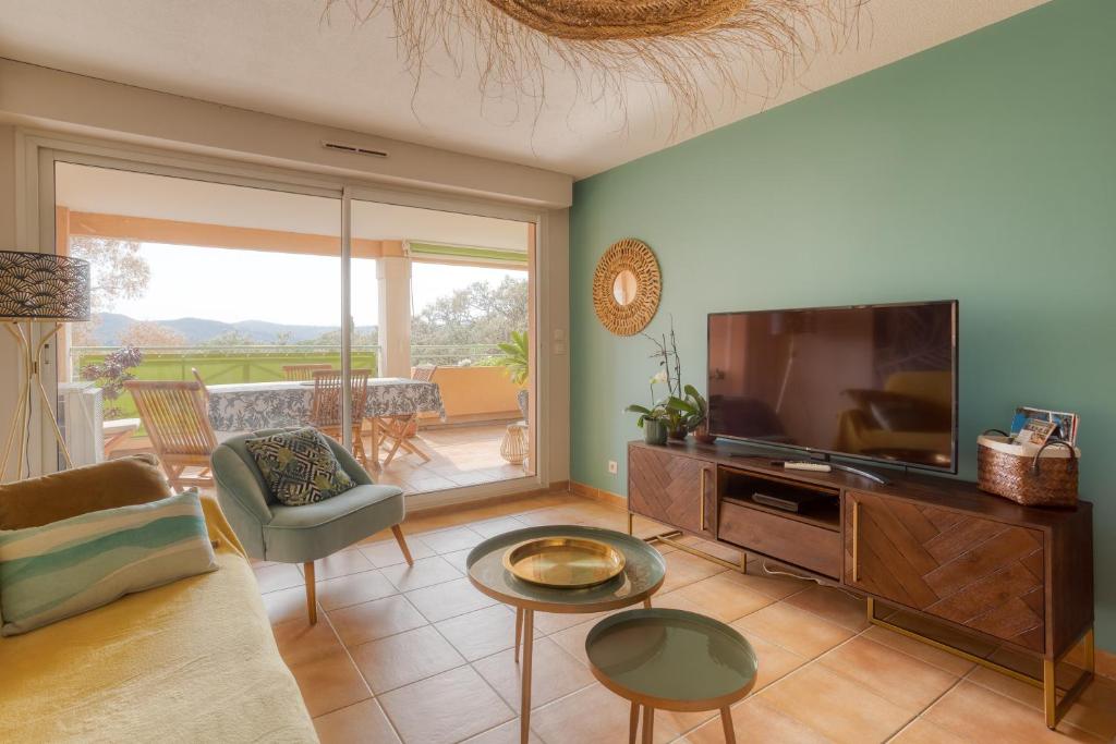 a living room with a television and a couch at Bel appartement classé 3 étoiles in Bormes-les-Mimosas