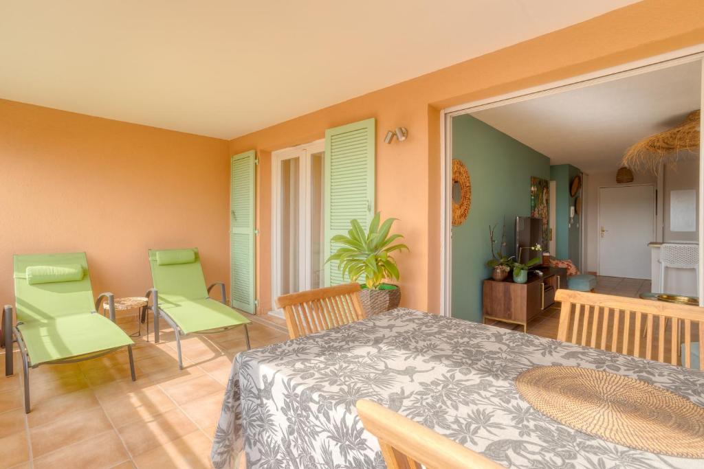 une salle à manger avec une table et des chaises vertes dans l'établissement Bel appartement classé 3 étoiles, à Bormes-les-Mimosas
