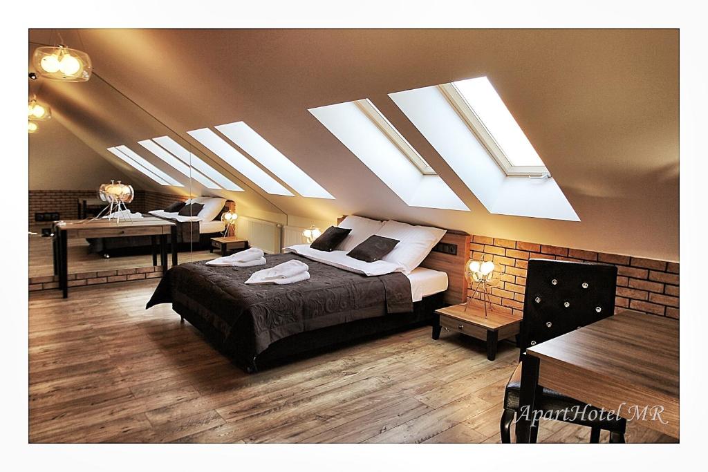 una camera da letto con lucernari, un letto e una scrivania di Apartamenty Piła a Piła