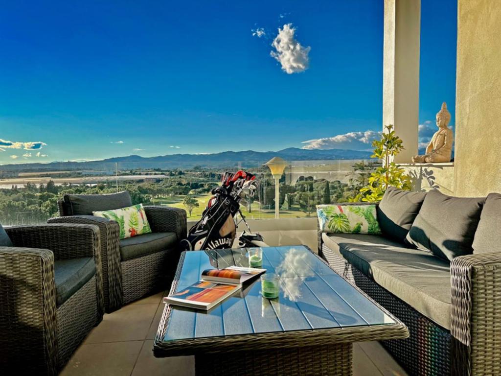 una sala de estar con sofás y una mesa en el balcón en Baviera Hills Holiday Apartment, en Caleta de Vélez