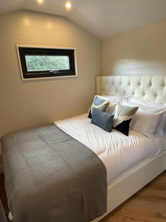 a bedroom with a large white bed with a window at Canalside View Mini Lodge with private hot tub in Llangollen