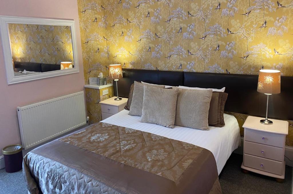 een slaapkamer met een groot bed en een gele muur bij Cornerways Guest House in Carlisle