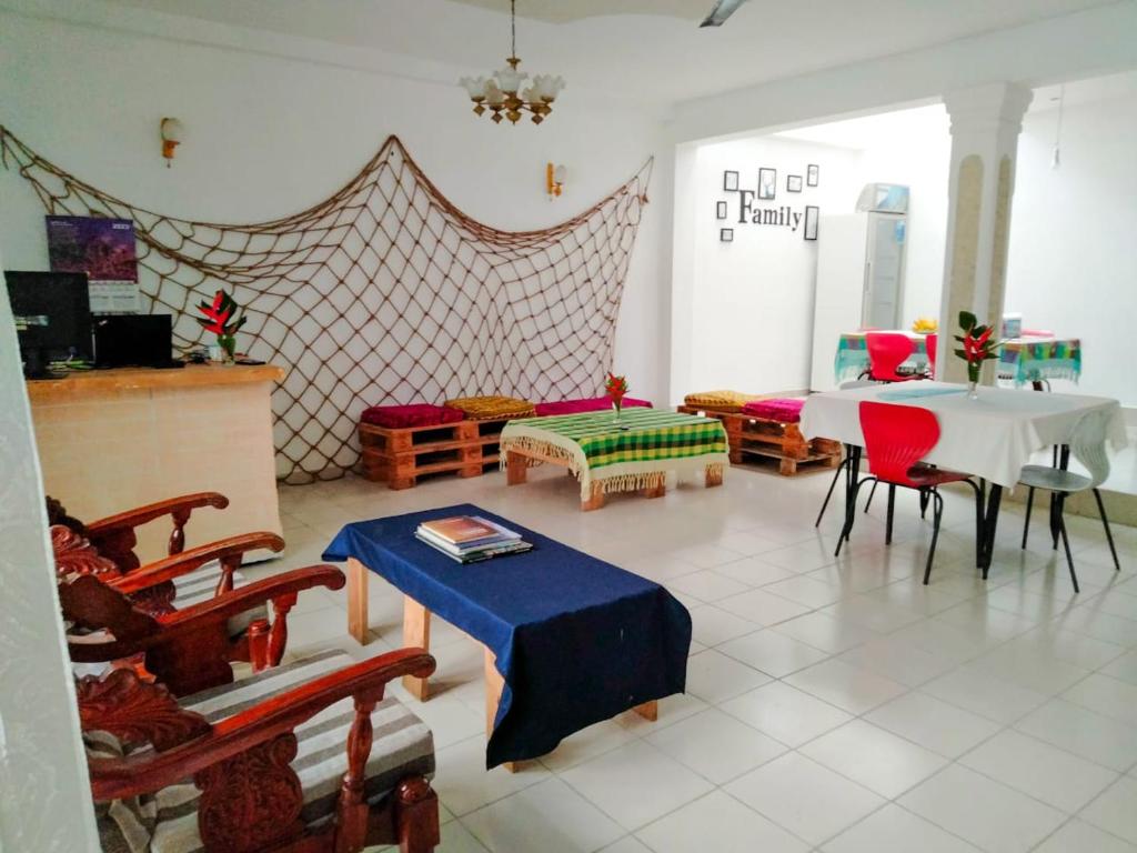 Backpacker Galle Hostel في غالي: غرفة معيشة مع طاولة وكراسي