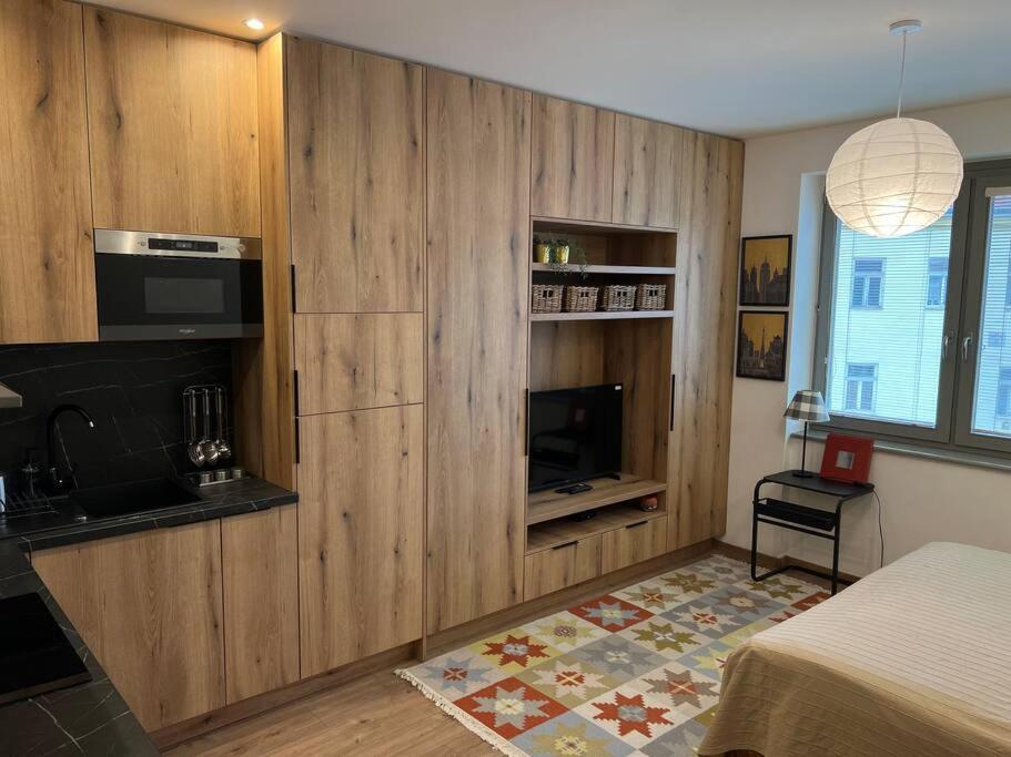 a bedroom with wooden cabinets and a bed and a television at Nové bývanie v centre Košíc. in Košice