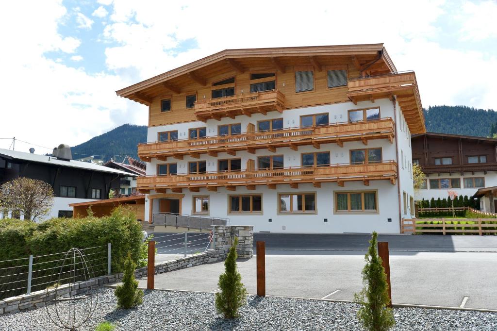 een groot houten gebouw met veel ramen bij Appartementhaus Spiegl by Travel Partner in Ellmau