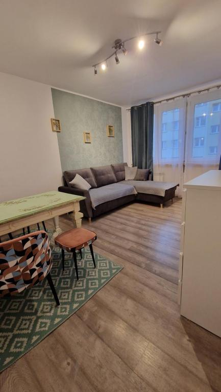 a living room with a couch and a table at Apartament na Moniuszki in Legnica