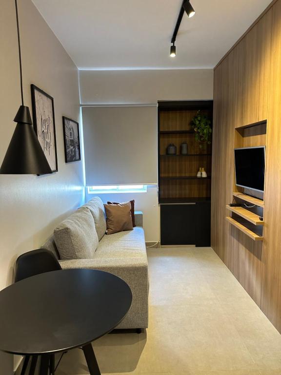 uma sala de estar com um sofá e uma mesa em Flat em Brasília - Moderno e equipado em Brasília