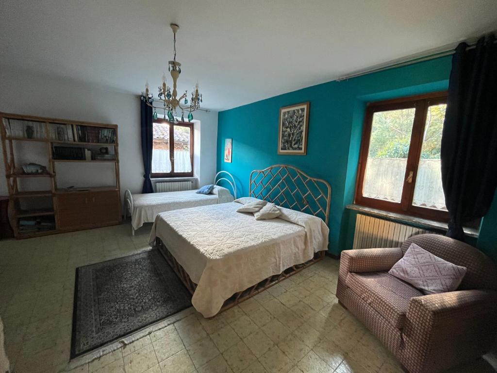 a bedroom with blue walls and a bed and a chair at Il gufo e il gatto del lago in Travedona